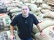 Michael Jones, Chief Executive Officer of THRIVE Farmers, in their Atlanta warehouse surrounded by bags of coffee beans grown from some of the best coffee growing regions in the world.
